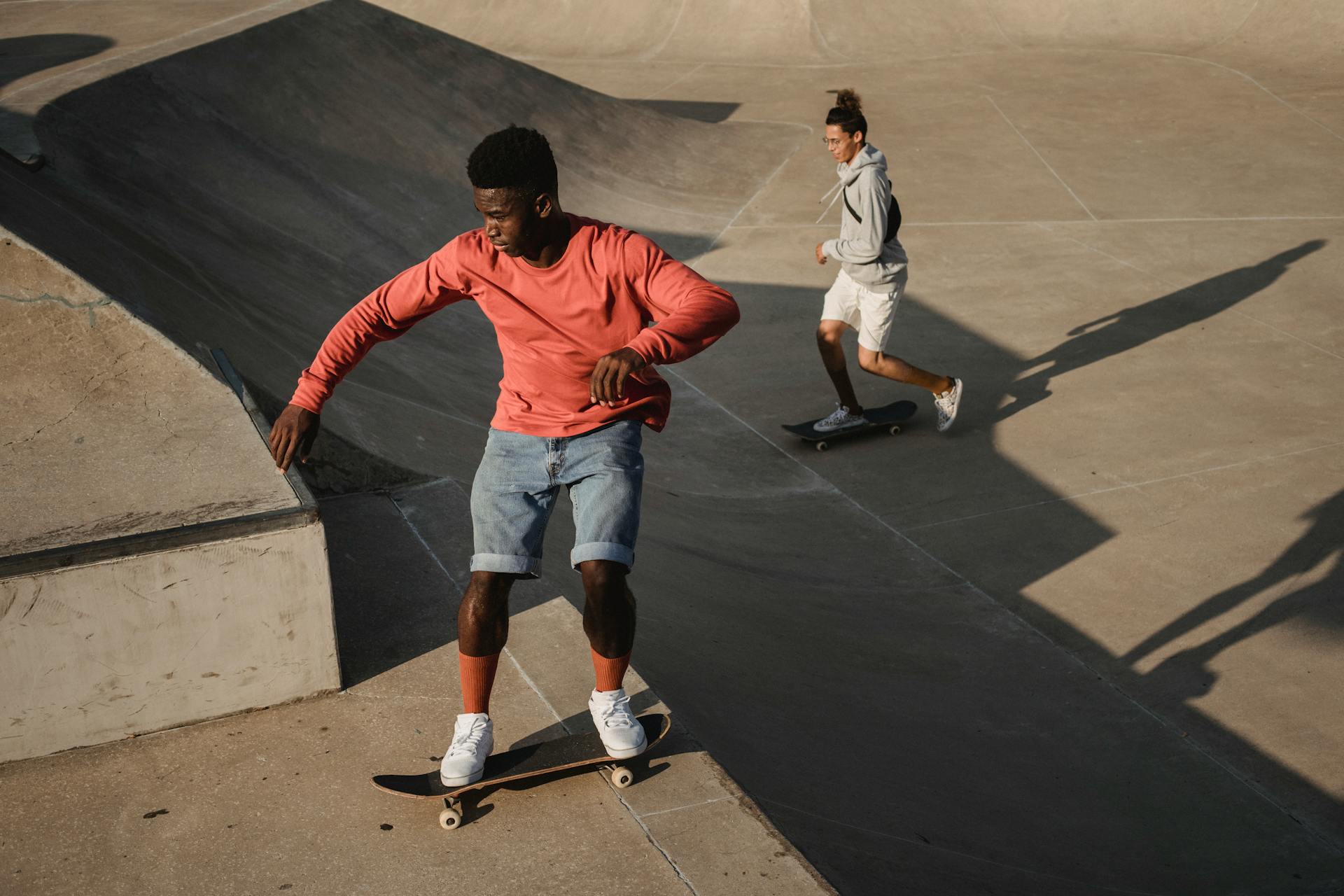 Young man finishing skateboard stunt on ramp in sunlight