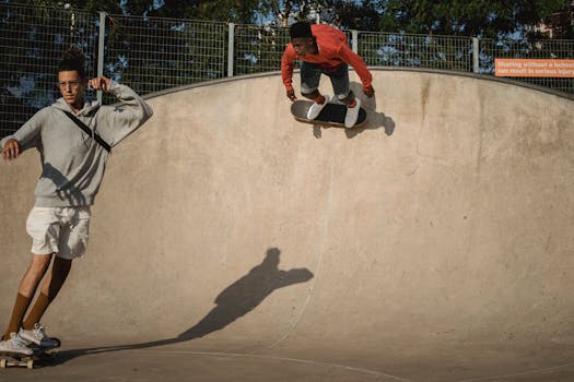 Full body of focused diverse friends riding skateboards together during training in skate park in daytime