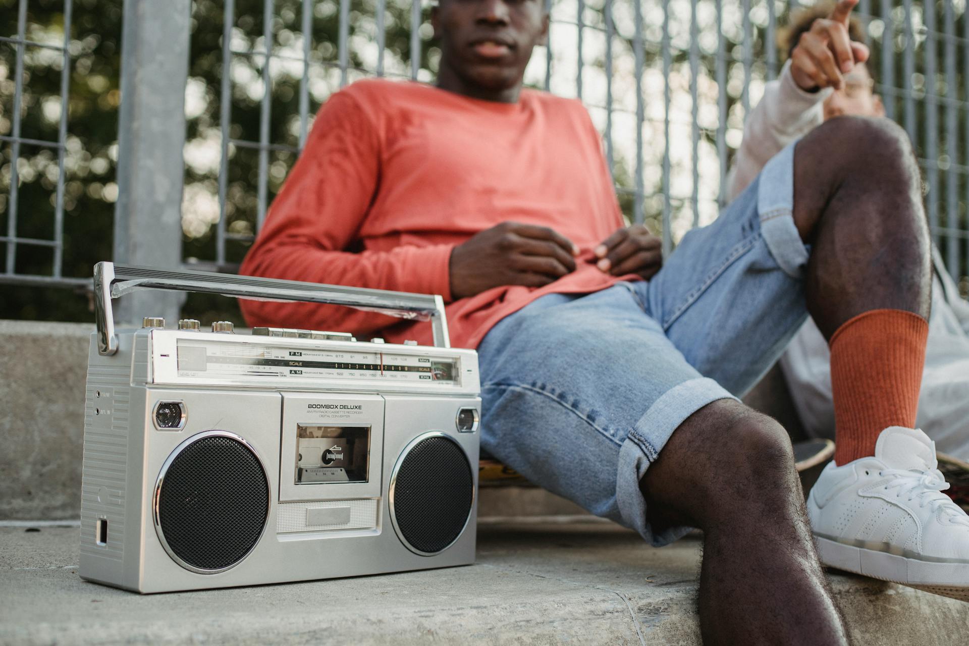 Diverse friends chilling on street with vintage radio cassette recorder