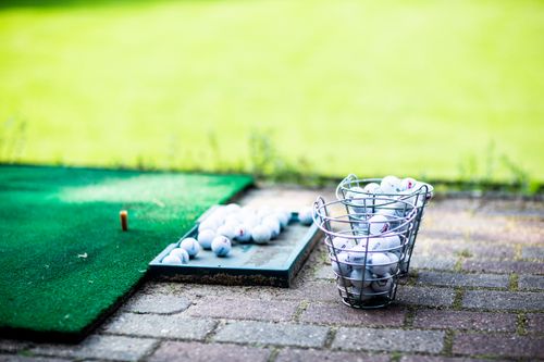 Free A collection of golf balls on a practice mat at an outdoor driving range on a sunny day. Stock Photo