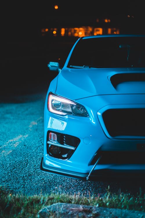 Free Modern automobile with luminous headlights parked on asphalt near lawn with grass in late evening Stock Photo