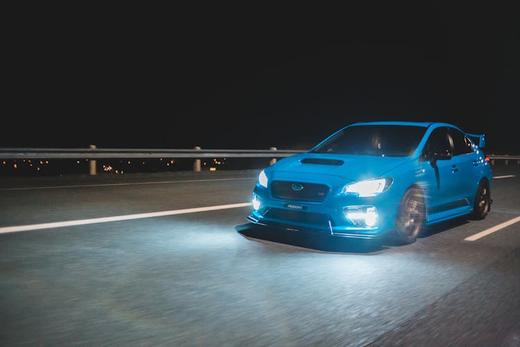 Contemporary Sport Car Driving Fast On Night Bridge