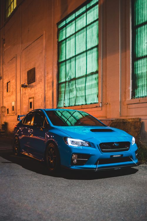 Free Contemporary blue automobile parked near aged house with large windows in late evening Stock Photo