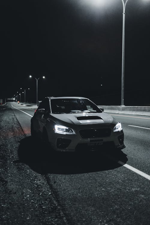 Car with bright headlights driving on highway