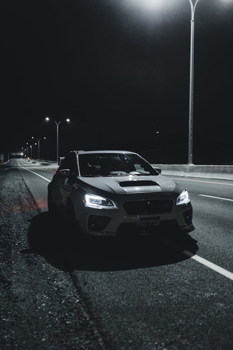 Car With Bright Headlights Driving On Highway