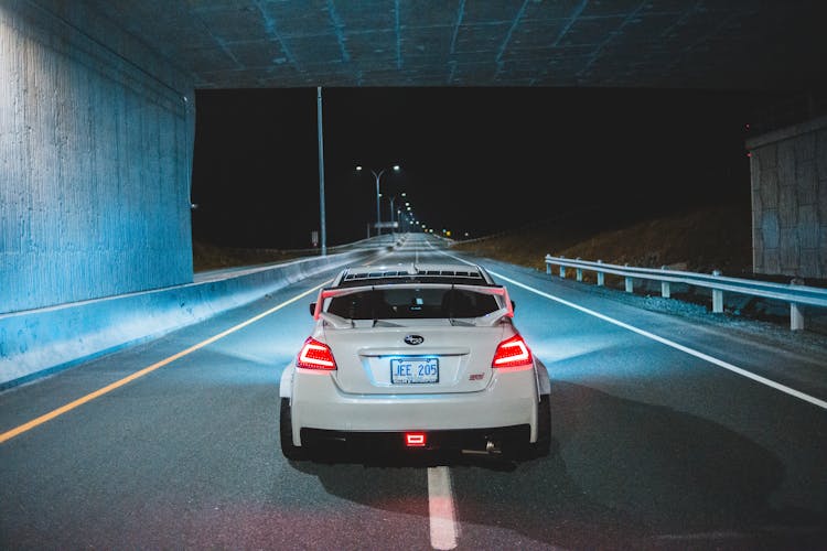 Modern Car With Bright Taillights Driving On Highway