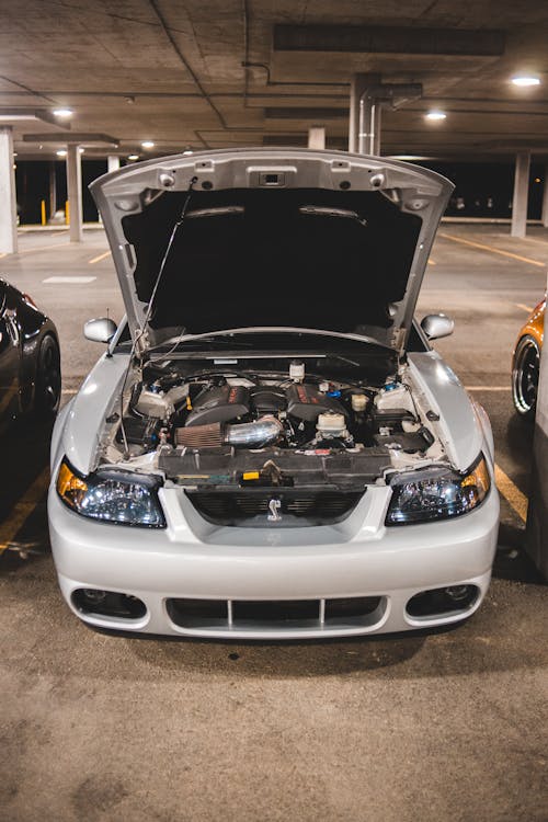 Opened hood of car on car parking