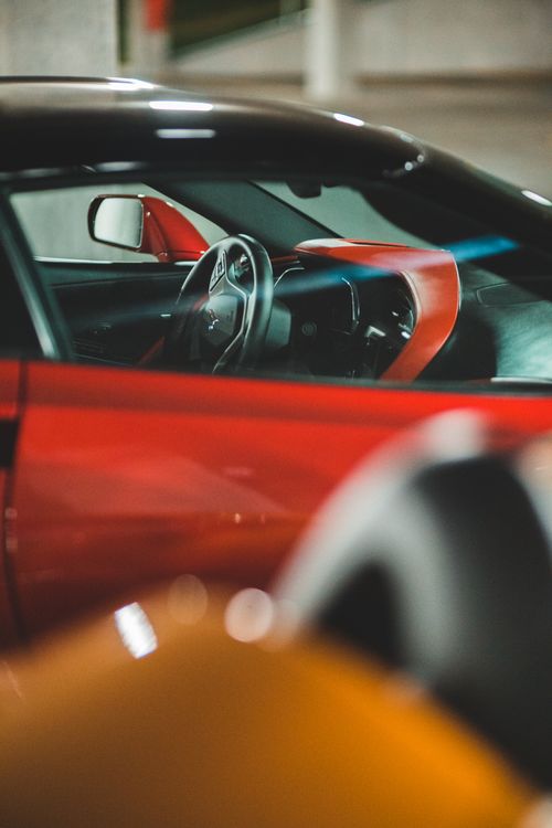 Free Shiny red colored automobile parked in row with modern car at parking lot Stock Photo
