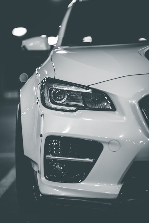 Free White colored luxury car with shiny headlights and glossy bumper parked at parking lot Stock Photo