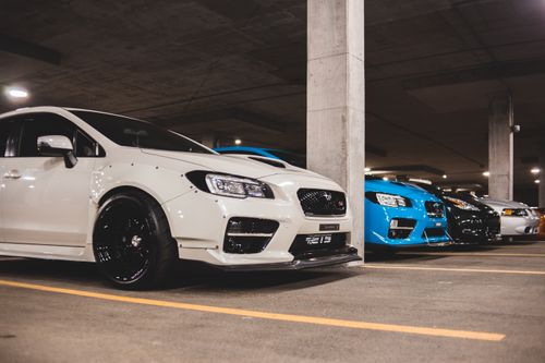 Free Contemporary stylish automobiles parked on asphalt between marking lines under concrete roof Stock Photo