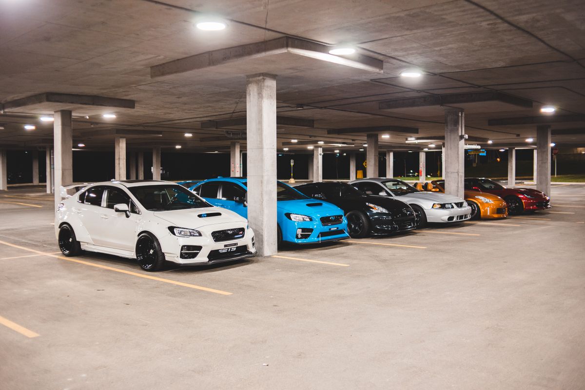 New automobiles stored under a covered parking structure representing vehicle storage overhead costs