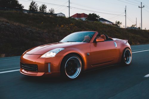 Free Modern shiny car with large headlights rushing on asphalt road in dusky evening Stock Photo