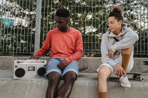 Diversi Giovani Amici Che Riposano Insieme Dopo L'allenamento Con Lo Skateboard