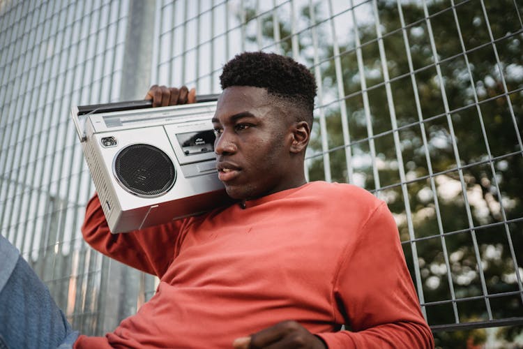 Black Man Listening To Music From Retro Cassette Recorder Outdoors