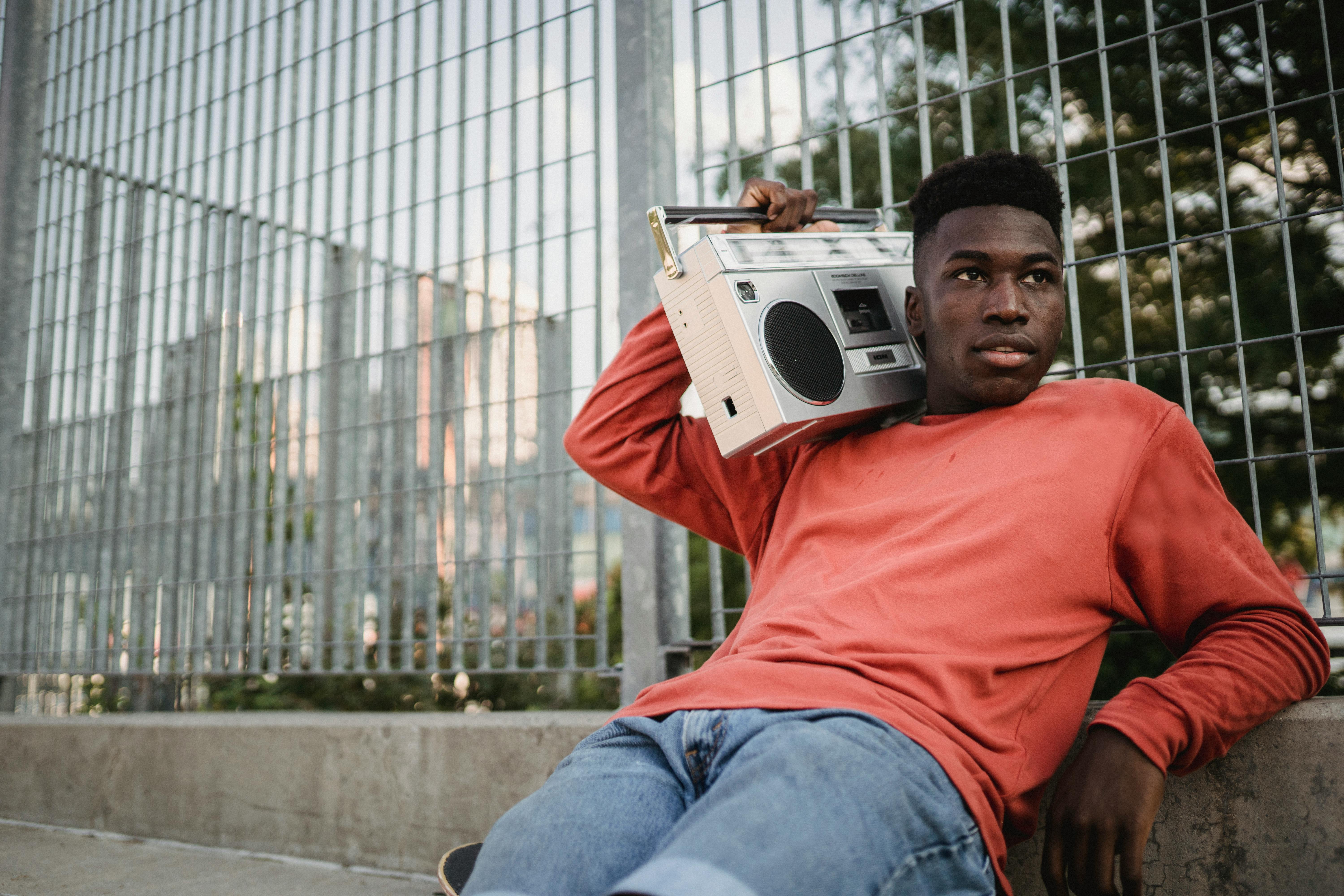 dreamy ethnic sportsman listening to song from old tape recorder