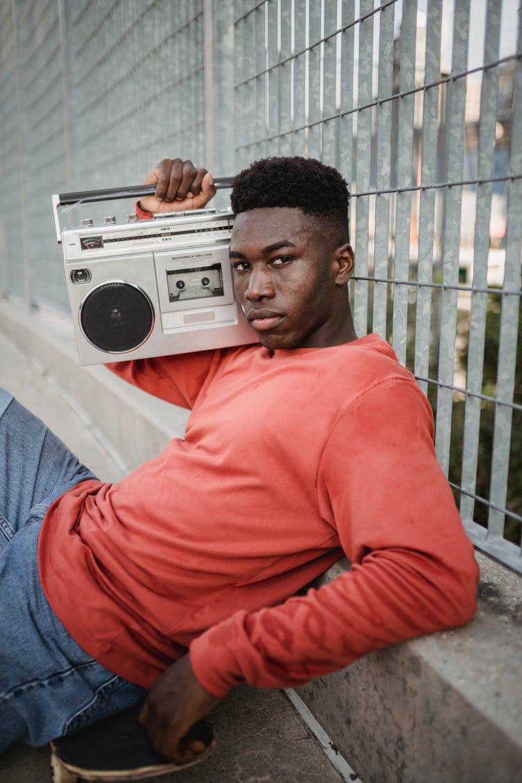 Black Skateboarder Listening To Music On Vintage Cassette Recorder Outdoors