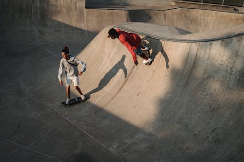 Anonymous diverse athletes skateboarding on platform in town