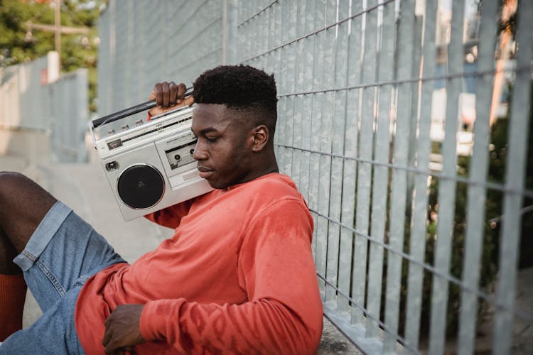 Pensive Black Man Listening To Music From Retro Cassette Recorder