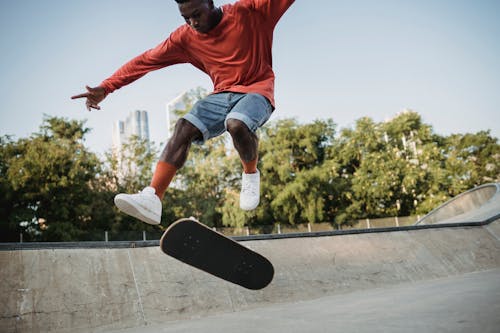 無料 スケートボードでジャンプするエネルギッシュな黒人男性 写真素材