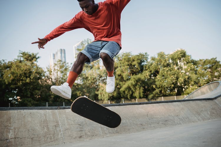 Energetic Black Man Jumping On Skateboard