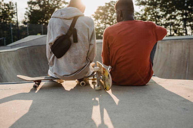 Diverse Skaters Resting On Ramp In Skate Park