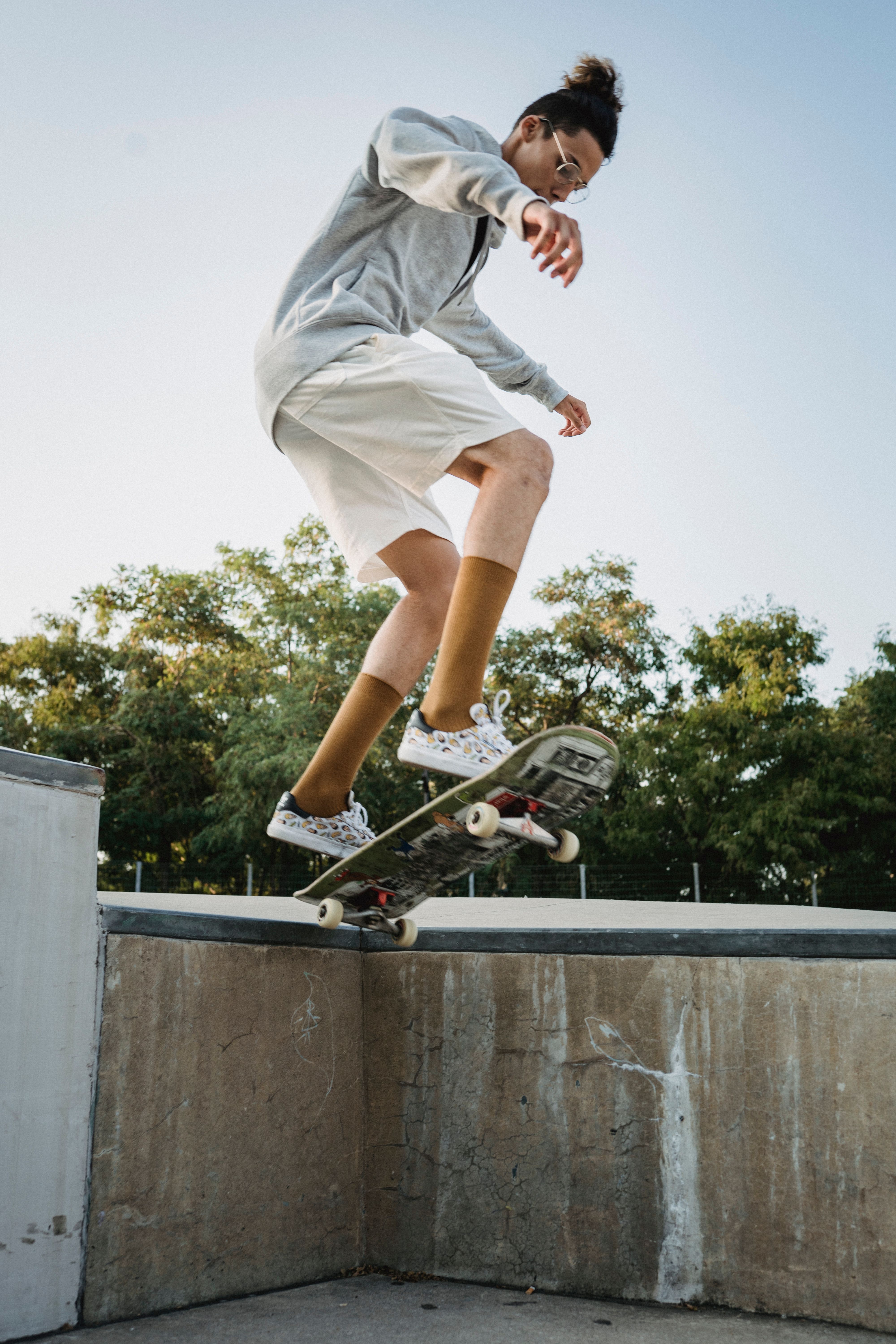 A young skateboarder in midair performing a trick at an outdoor skate park.