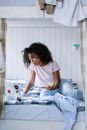 Woman Sitting on Bed Eating an Apple