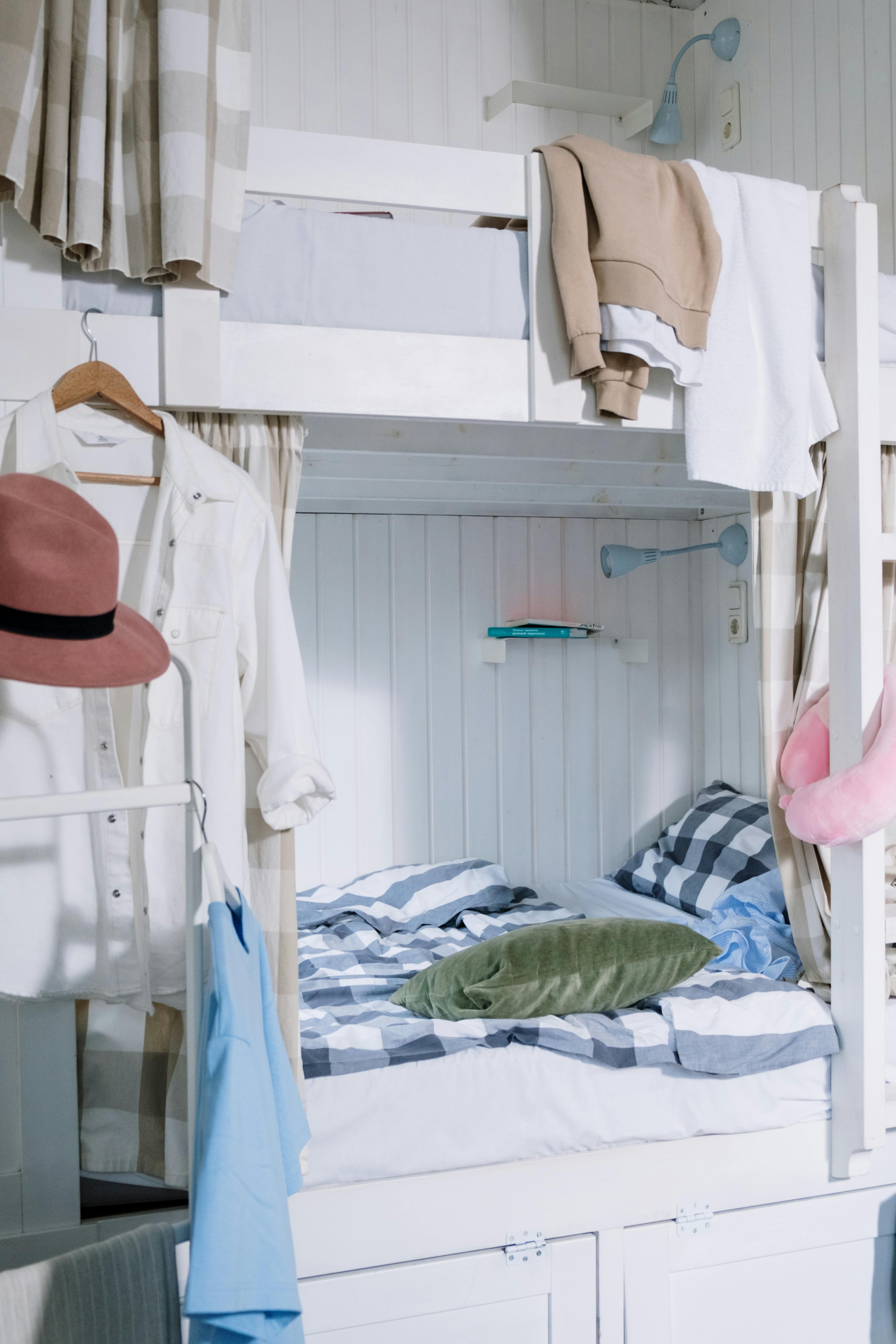 A Bunk Bed With Striped Linen Behind Bars · Free Stock Photo