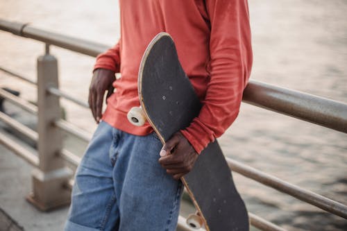 Crop black man with skateboard