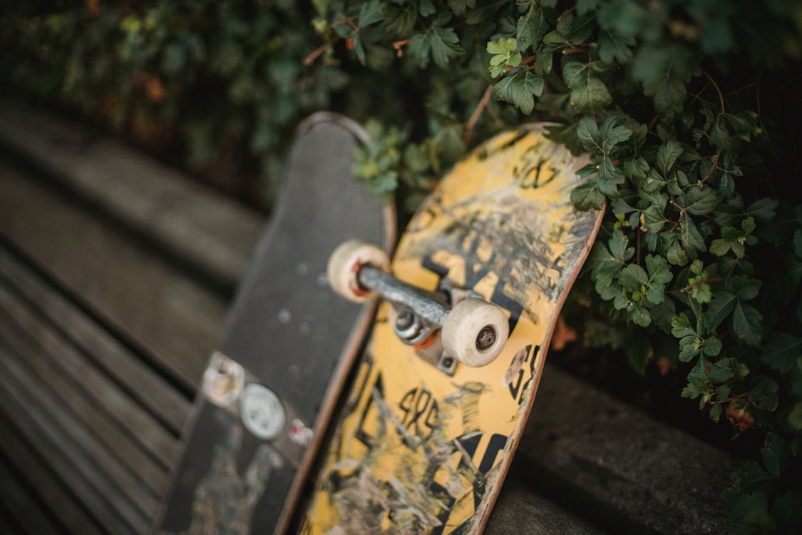 Skateboards placed on bench near fence · Free Stock Photo