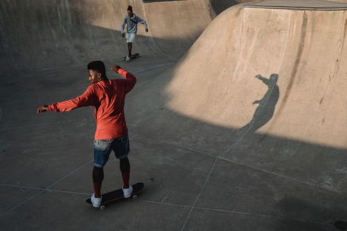 Free Two young men skateboarding in an urban concrete skate park under daylight. Stock Photo