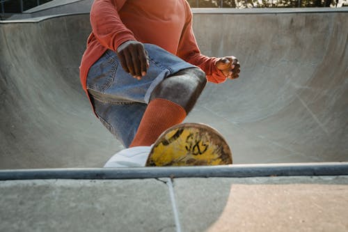 Crop skater performing trick on skateboard