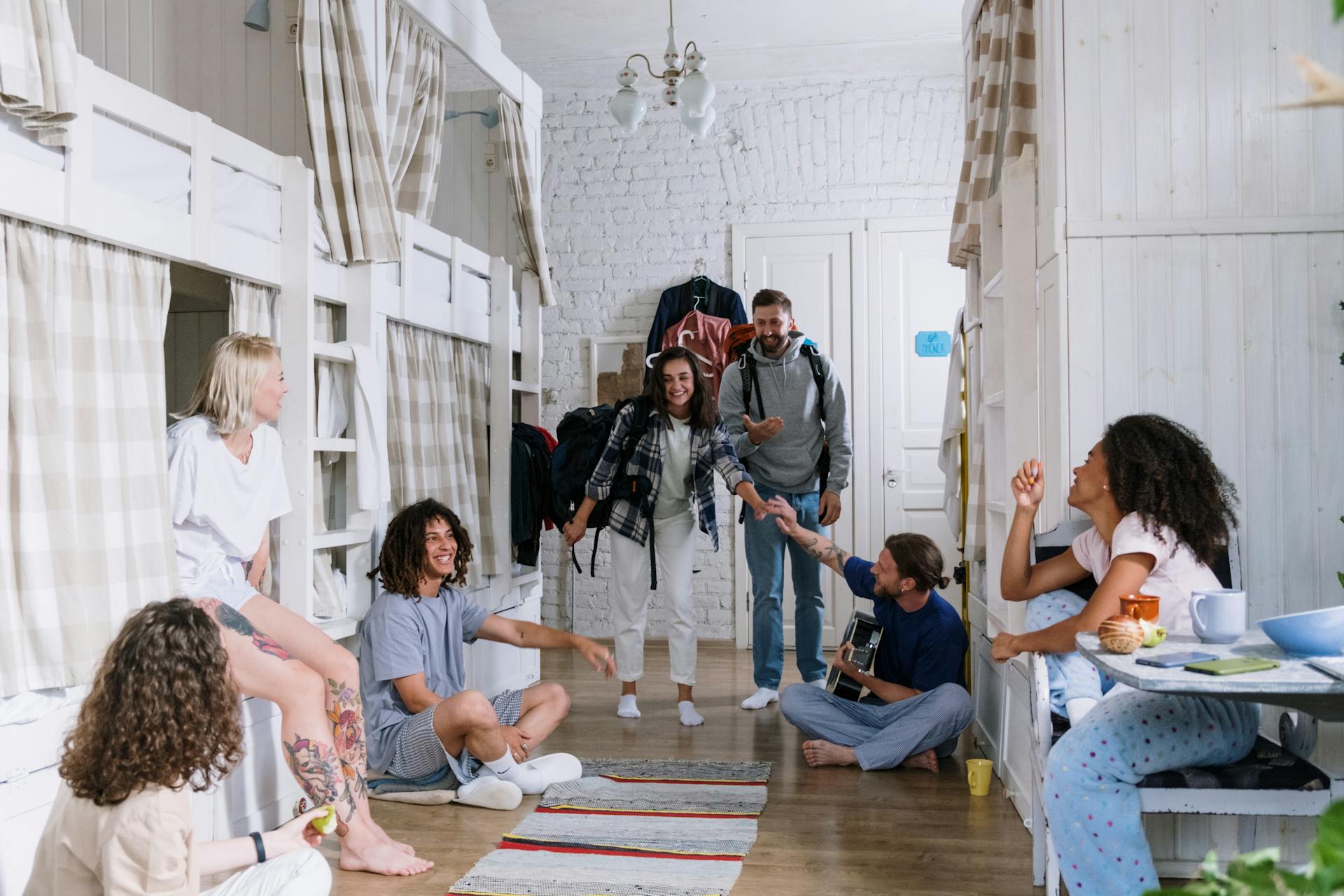 A diverse group of friends enjoying each other's company in a cozy dorm room, creating a warm and vibrant atmosphere.