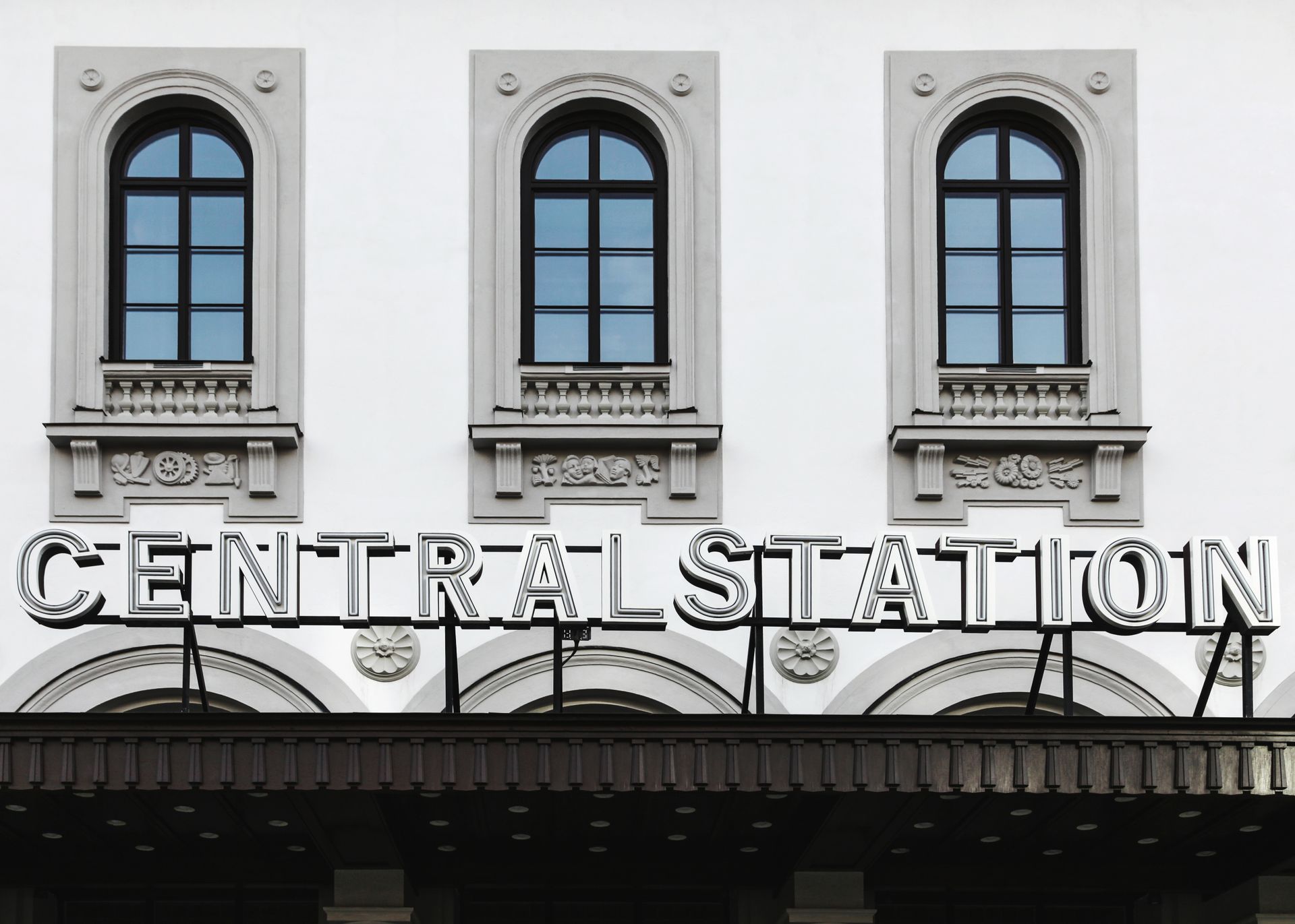 A classic architecture facade with arched windows and signage of Central Station.