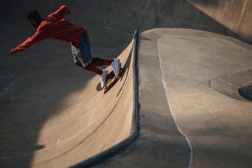 Free A man skateboards on a ramp in the outdoor skate park, showcasing athleticism and skill. Stock Photo