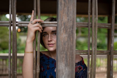 Free Content woman standing near wooden bars Stock Photo