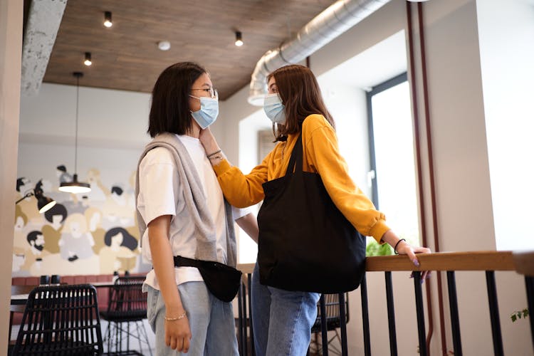 Couple In Facemasks Talking In Cafe