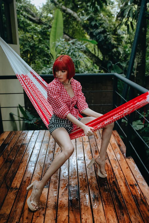 Extravagant stylish woman sitting on hammock on terrace