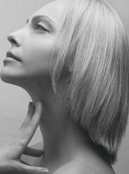 Free Grayscale Photo of a Woman with Hand on Neck Stock Photo