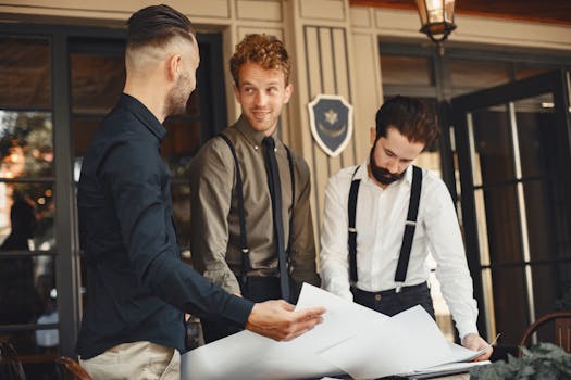 Three young professionals engaged in discussion over architectural plans indoors.