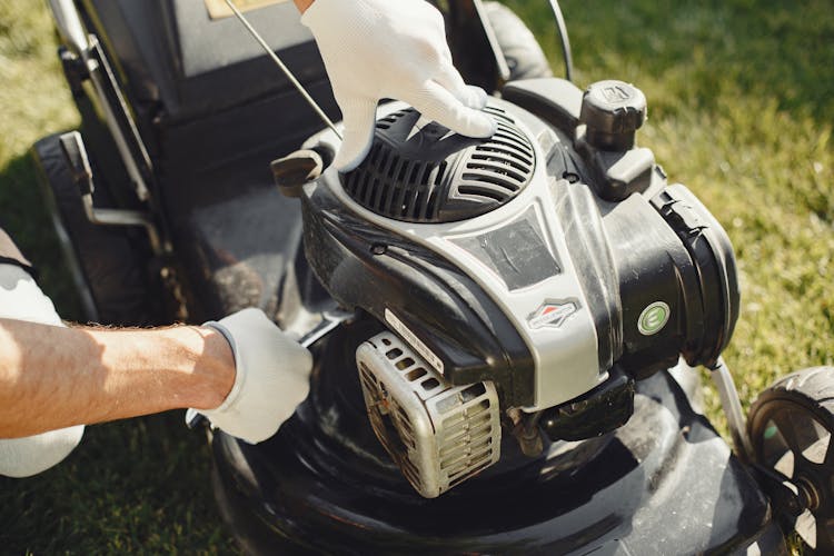 Person Holding Black And Gray Lawn Mower