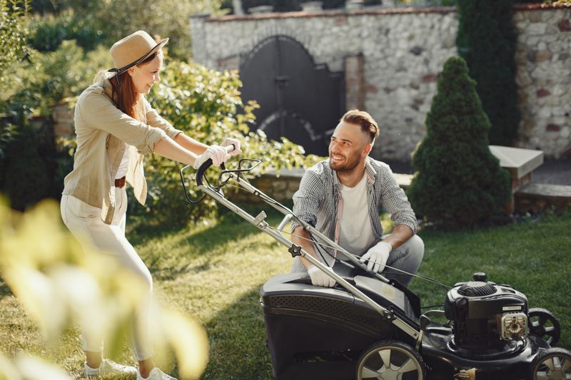 Lawn care worker mowing and maintaining yards for local residential clients