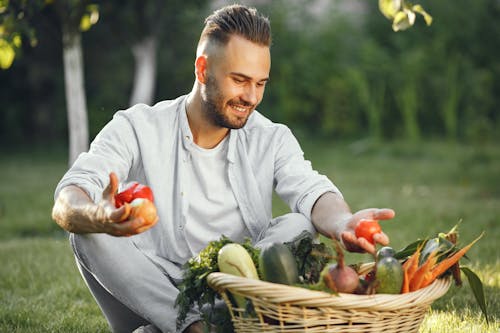 Man in White Long Sleeve Shirt Holding Fresh Vegetables