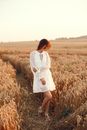 Young Woman in Dress in Hay Field