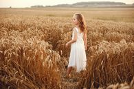 Woman in White Sleeveless Dress Standing on Wheat Field