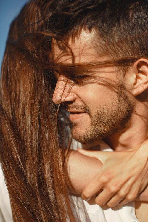 Free Endearing close-up of a couple sharing an affectionate embrace outdoors. Stock Photo