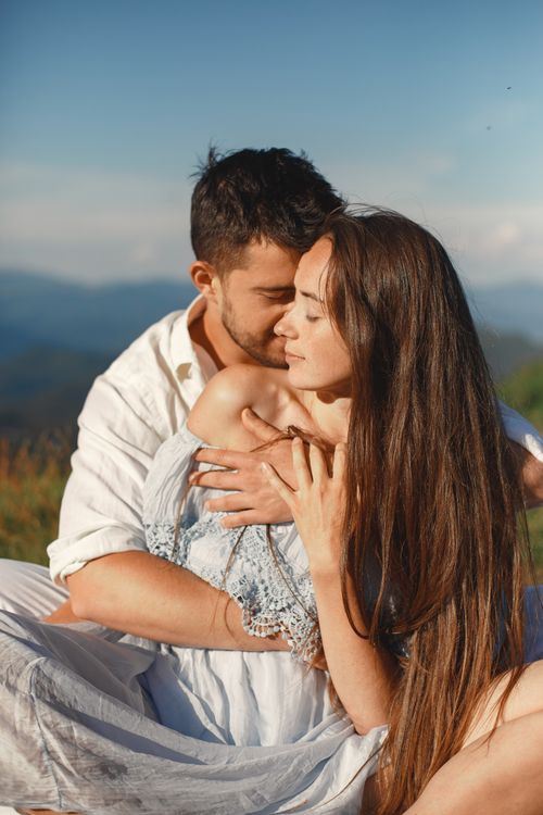 Free A loving couple shares a tender moment outdoors, enjoying a warm embrace in the sunlight. Stock Photo