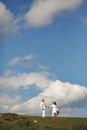 Man in White T-shirt and Black Pants Standing Under Blue Sky