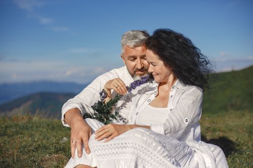Free A loving couple embraces outdoors, enjoying nature and sunshine. Stock Photo