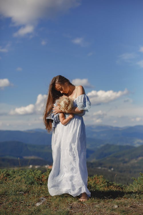 Woman in White Dress Carrying Baby